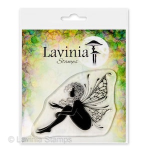 May include: Clear cling stamp featuring a silhouette of a fairy with intricate wings sitting with her arms resting on her legs. The stamp is packaged in a clear plastic bag with the Lavinia Stamps logo and the text "Lavinia Stamps".