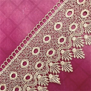 May include: Gold lace trim with a scalloped edge and a delicate floral pattern. The lace has a repeating pattern of circles and small flowers.
