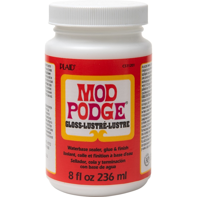 May include: A white plastic bottle of Mod Podge Gloss-Lustre waterbase sealer, glue & finish. The label is red with the product name in large, pink and orange letters. The bottle contains 8 fl oz (236 ml).