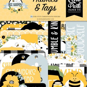 May include: A collection of die-cut cardstock pieces with a bee theme. The set includes frames and tags in yellow, black, white, and blue, with floral and honeycomb patterns. Text includes "Bee Happy", "Humble & Kind", and "Cute Works For".