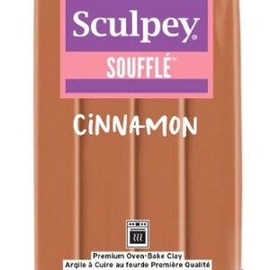 Pu&ograve; includere: Una confezione da 198 grammi di pasta modellabile da forno Sculpey Souffle Cannella. La confezione &egrave; viola con un'etichetta rosa e presenta il logo Sculpey e le parole "Souffle" e "Cannella".