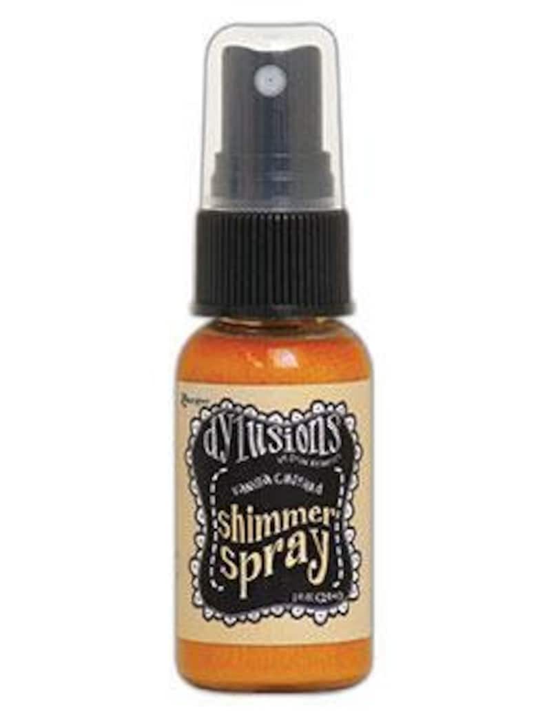 May include: A small bottle of gold shimmer spray with a black spray nozzle and a white label that says "Dylushions Shimmer Spray".