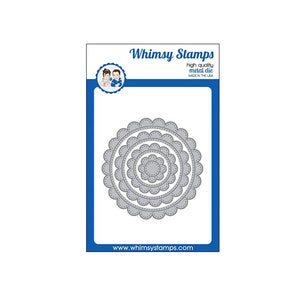 May include: A set of four metal die cuts in the shape of scalloped circles. The die cuts are nested within each other, with the smallest circle in the center. The die cuts are silver in color and have a textured finish. The die cuts are made by Whimsy Stamps and are made in the USA. The website address www.whimsystamps.com is printed below the die cuts.