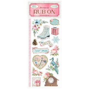 May include: A sheet of rub-on transfers featuring a winter theme with images of ice skates, a pine cone, a bird, a clock, a horse, flowers, and the words "Sweet Winter" and "Christmas".