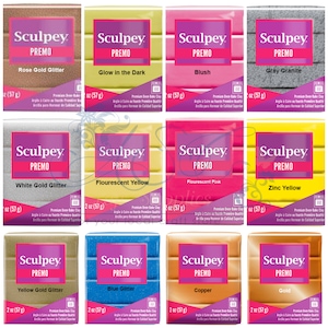 Op de afbeelding: Assortiment van 10 Sculpey Premo polymeerklei kleuren, waaronder Rosegoud Glitter, Glow in the Dark, Blush, Grijs Graniet, Witgoud Glitter, Fluorescerend Geel, Fluorescerend Roze, Zinklegering, Geelgoud Glitter, Blauw Glitter, Koper en Goud. Elke 2 ounce (57 gram) blok klei is gelabeld met de kleurnaam en Sculpey Premo.