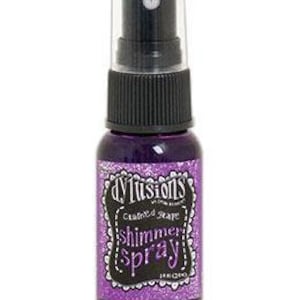 May include: A small bottle of purple shimmer spray with a black cap and label that reads "dylusions  Crafted Stave Shimmer Spray  Ink-Crado".