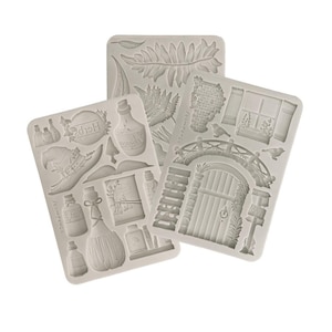 May include: Three silicone molds with various designs. One mold features a witch's hat, bottles, and the word "Herbs". Another mold has a bridge, door, and window. The third mold has fern leaves. All molds are light gray.