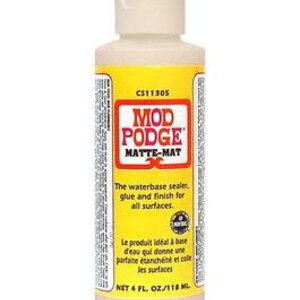 May include: A 4-ounce bottle of Mod Podge Matte-Mat water-based sealer, glue, and finish for all surfaces. The bottle is white with a yellow label and the text "CS11305 Mod Podge Matte-Mat" printed on it.