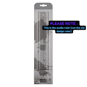 May include: Clear plastic 12" x 2" media ruler in a gray and white package. The ruler has inch markings and is labeled "Media Ruler" with the text "PLEASE NOTE - This is the media ruler (not the old design ruler)".