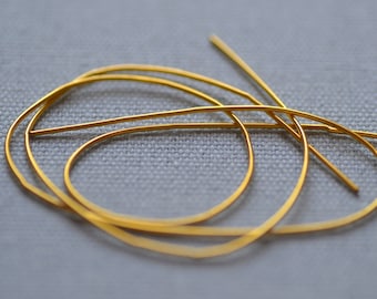 May include: Gold wire jewelry findings, a set of three, in a twisted and looped design. The wire is thin and delicate, and the loops are small.