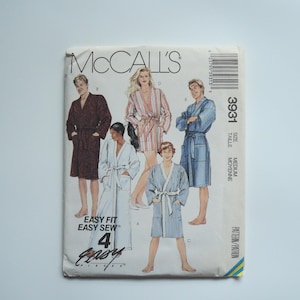 Könnte beinhalten: Ein Schnittmuster für vier Roben, mit einer gestreiften Robe, einer einfarbigen blauen Robe, einer einfarbigen braunen Robe und einer gestreiften Robe. Das Schnittmuster ist mit "McCall's 3931 Easy Fit Easy Sew 4 Easy" beschriftet.