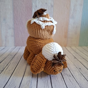 Peut inclure: Un bonhomme en pain d'épices au crochet avec un chapeau en glaçage blanc et une décoration en badiane. Le bonhomme en pain d'épices est marron avec un chapeau en glaçage blanc et une décoration en badiane. Sur une surface en bois.