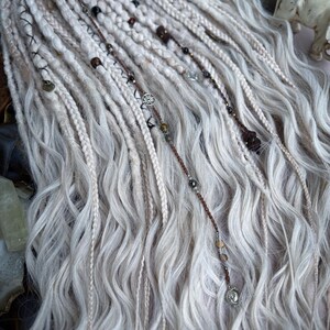 May include: White synthetic dreadlocks with brown and silver beads and charms.