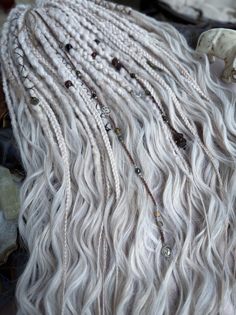 May include: White synthetic dreadlocks with brown and silver beads and charms.