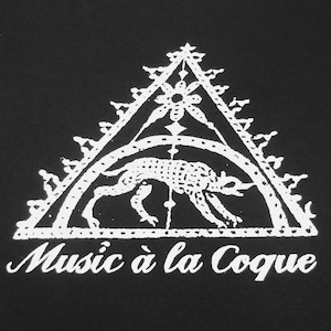 Könnte beinhalten: Schwarzes T-Shirt mit weißem Grafikdesign. Das Design zeigt ein Dreieck mit verzierten Kanten, ein florales Element und eine stilisierte Tierfigur. Der Text "Music à la Coque" steht darunter.