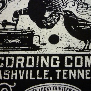 May include: Black and white image of a vintage record player with a crow perched on top. The text "RECORDING COMPANY NASHVILLE, TENNESSEE" is printed below the image.
