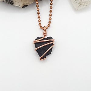 May include: A copper chain necklace with a shungite stone wrapped in copper wire.