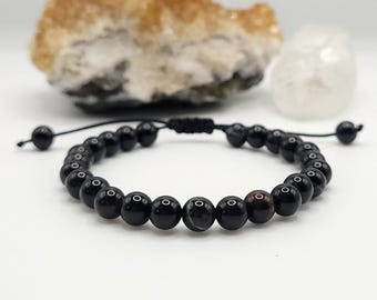 Könnte beinhalten: Armband aus schwarzen Achatperlen mit schwarzem Band und verstellbarem Knotenverschluss.