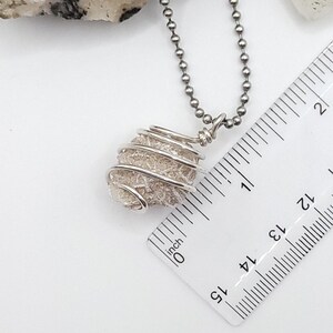 desert rose selenite necklace wrapped in silver wire on silver ball chain nec to ruler , measuring about 1 1/4"