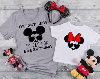May include: Two gray and white t-shirts with a Mickey Mouse and Minnie Mouse design. The gray shirt says "I'm just here to pay for everything".