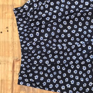 Puede incluir: Una tela azul marino con un estampado floral blanco. La tela tiene una cintura el&aacute;stica fruncida.