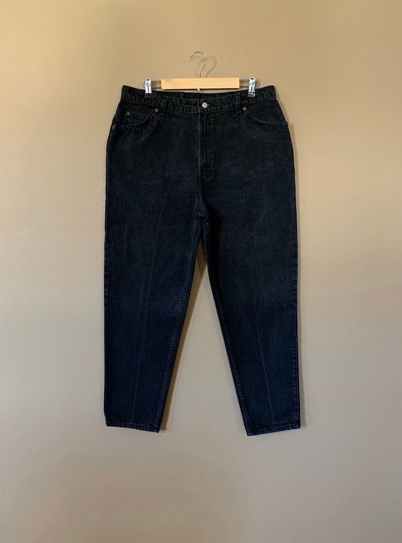 May include: Black high-waisted jeans with a straight leg fit.