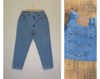 May include: Light blue denim jeans with a high waist and a straight leg. The jeans have a classic five-pocket style and a Levi's patch on the back right pocket.