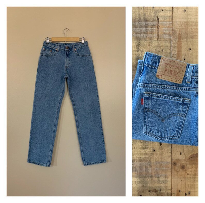 May include: Light blue denim jeans with a red tab and a Levi's patch on the back pocket.