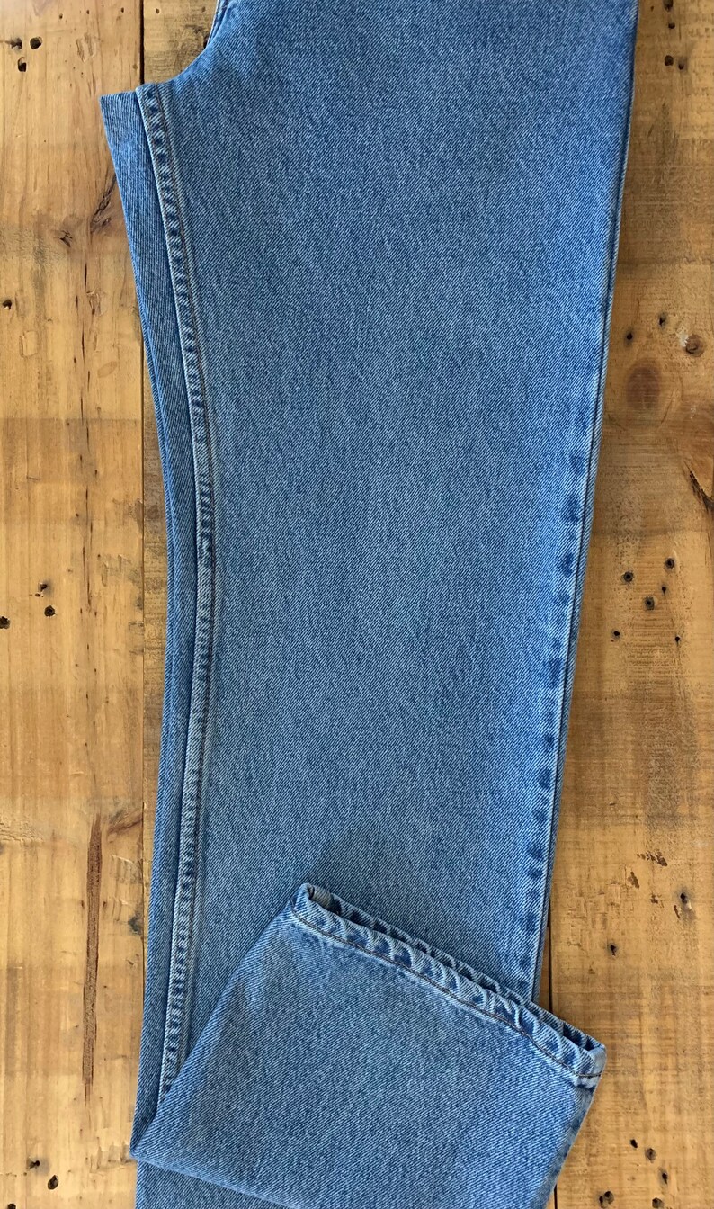 May include: A pair of light blue denim jeans with a straight leg and a classic fit.