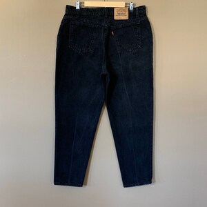 May include: Black denim jeans with a Levi's brand label on the back pocket.