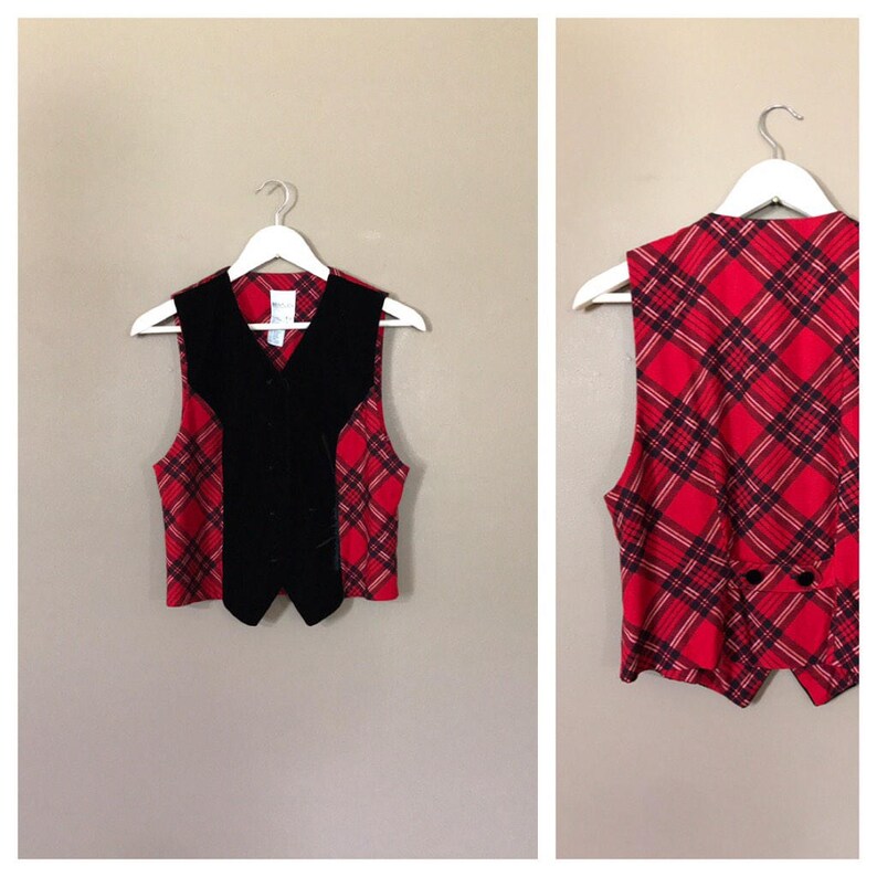 May include: A red and black plaid vest with a black velvet front panel. The vest has a button closure and a pointed collar.