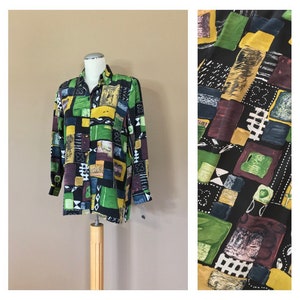 May include: A long-sleeved button-up shirt with a geometric print in shades of green, yellow, blue, and red on a black background.