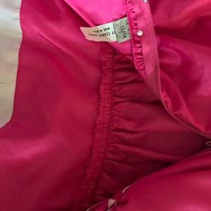 Puede incluir: Vestido rosa con estampado blanco y rosa. El vestido tiene una cremallera y una etiqueta que dice "13/14 Y CLEAN ONLY Made in B.R."