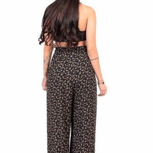 Puede incluir: Pantal&oacute;n negro de pierna ancha con estampado floral dorado. El pantal&oacute;n tiene cintura alta y un corte holgado.
