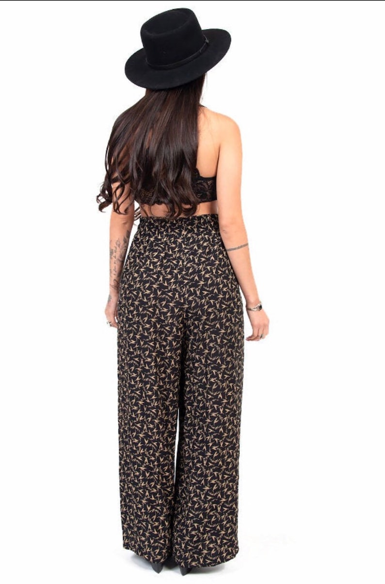 Puede incluir: Pantal&oacute;n negro de pierna ancha con estampado floral dorado. El pantal&oacute;n tiene cintura alta y un corte holgado.