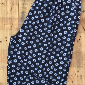 Puede incluir: Pantal&oacute;n azul marino con estampado floral blanco. El pantal&oacute;n tiene una cintura el&aacute;stica.
