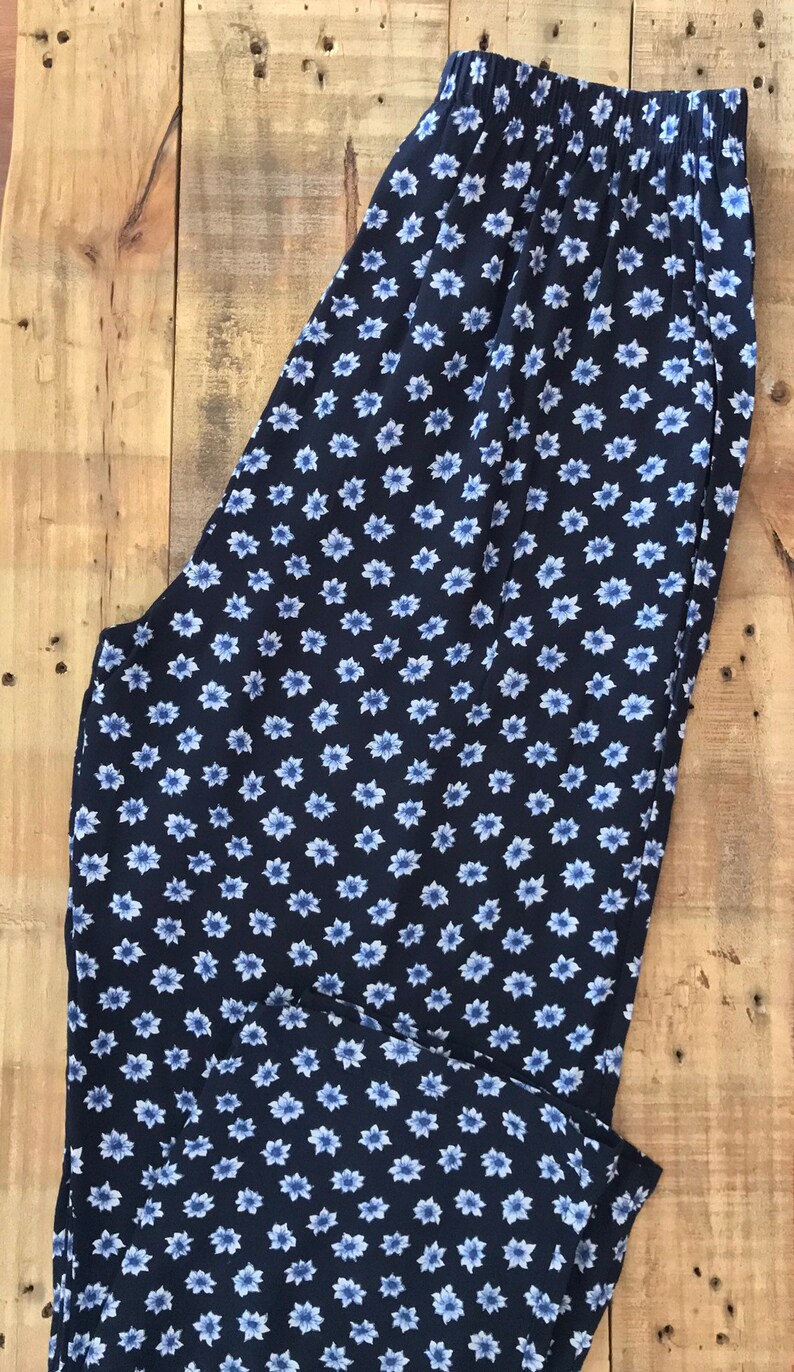 Puede incluir: Pantal&oacute;n azul marino con estampado floral blanco. El pantal&oacute;n tiene una cintura el&aacute;stica.