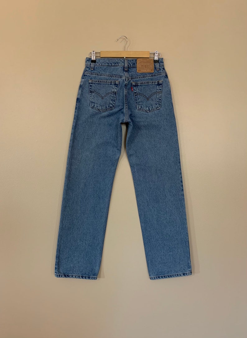 May include: A pair of blue denim jeans with a brown leather Levi's patch on the back.