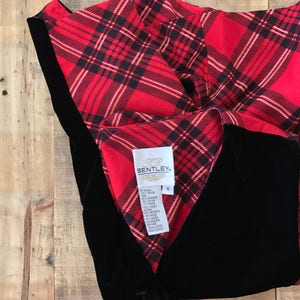 May include: Black velvet vest with a red and black plaid lining. The vest has a button closure and a label that reads "Bentley" with size 6.