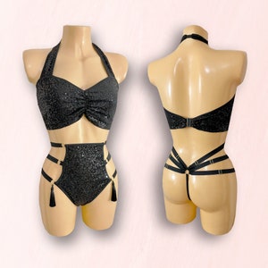 Op de afbeelding: Zwarte, met pailletten bezette lingerie set met een haltertop en een hoge taille broek met een kruisband ontwerp en kwastjes.