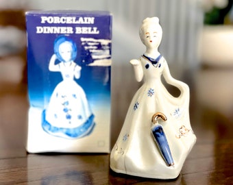 Campana de porcelana vintage con forma de dama: figura azul y blanca.
