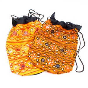 May include: Two small, drawstring bags with black fabric and orange and yellow embroidered designs. The bags are decorated with small, round mirrors.