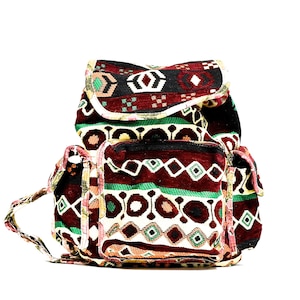 May include: A red, green and white patterned backpack with a flap closure and two front pockets.