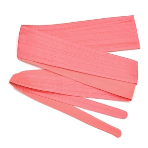 May include: A pink fabric belt with a quilted design. The belt is tied in a knot and the ends are hanging loose.