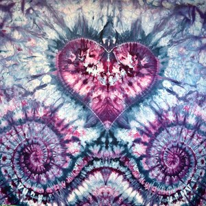 May include: A tie-dye fabric with a large heart shape in the center. The heart is surrounded by a swirling pattern of blue, purple, and white.