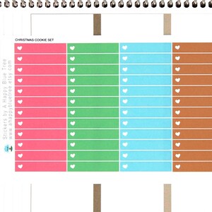 May include: A set of Christmas cookie stickers featuring a variety of colors and designs. The stickers are arranged in rows and columns on a white background. The text "CHRISTMAS COOKIE SET" is printed at the top of the image.