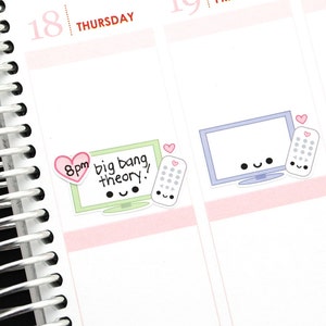 May include: A planner page with two stickers. The first sticker is green and has a cartoon television with the text "8pm big bang theory!" and a pink heart. The second sticker is blue and has a cartoon television with a pink heart and a remote control.