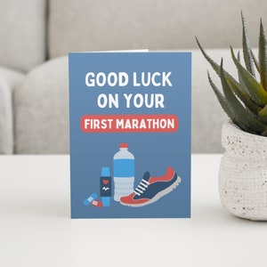 Men's first marathon good luck card in blue and red on sideboard