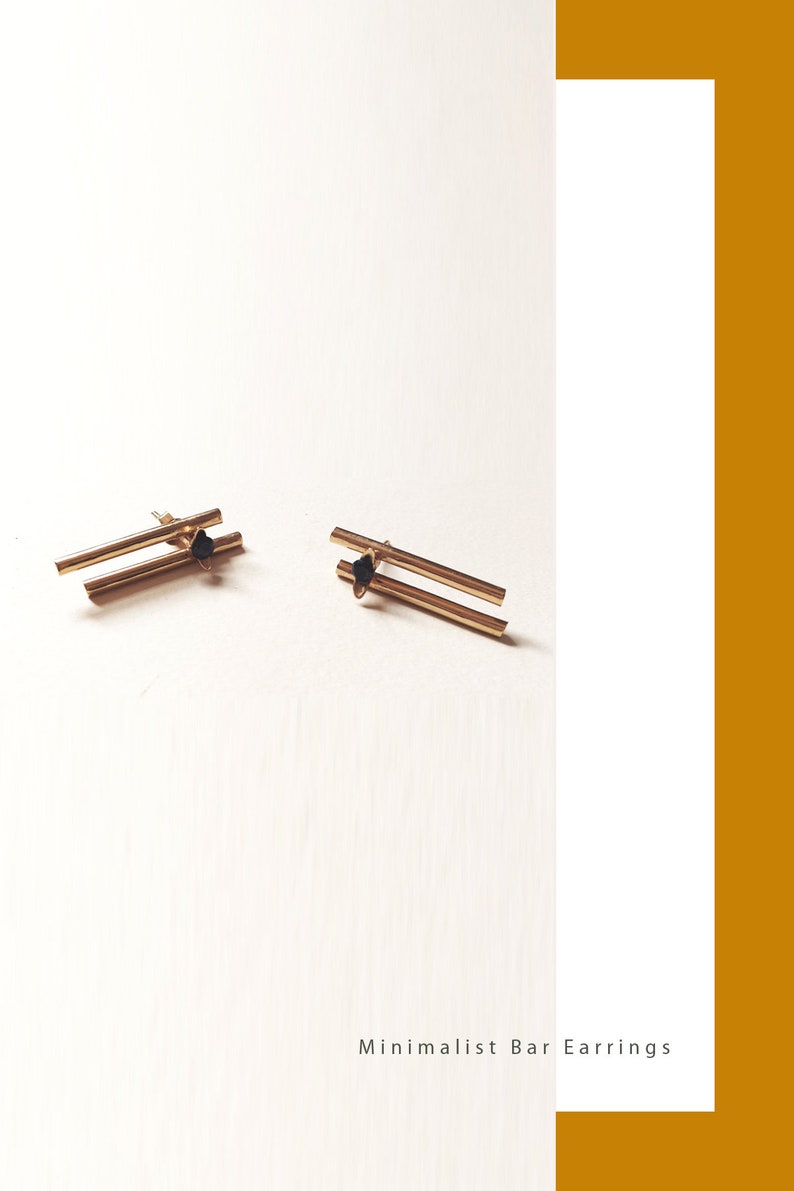 May include: A pair of minimalist gold bar earrings with black accents. The earrings are on a white background with the text "Minimalist Bar Earrings".