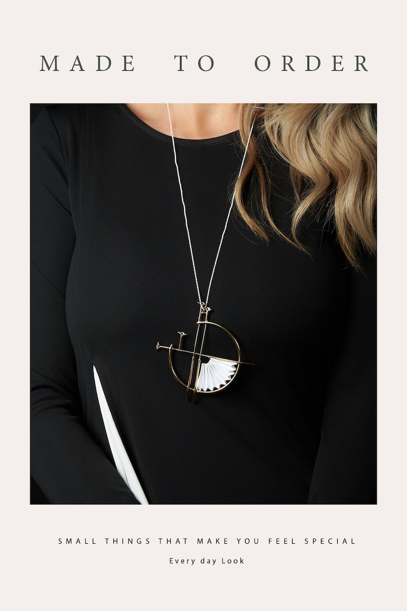 Puede incluir: Un collar de oro con un colgante geom&eacute;trico que presenta un dise&ntilde;o de abanico de papel blanco. El colgante est&aacute; suspendido de una fina cadena plateada. El collar lo lleva una persona con el pelo largo rubio y una camisa negra. El texto "MADE TO ORDER" est&aacute; en la parte superior de la imagen y el texto "SMALL THINGS THAT MAKE YOU FEEL SPECIAL" est&aacute; en la parte inferior de la imagen. El texto "Every day Look" est&aacute; centrado debajo del texto anterior.